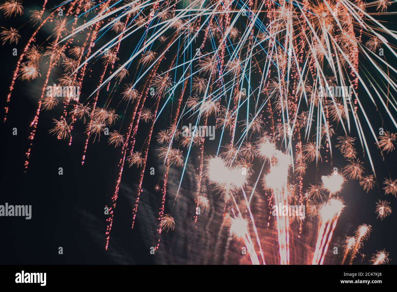 Low angle shot of fireworks of various colors exploding against a black background Stock Photo