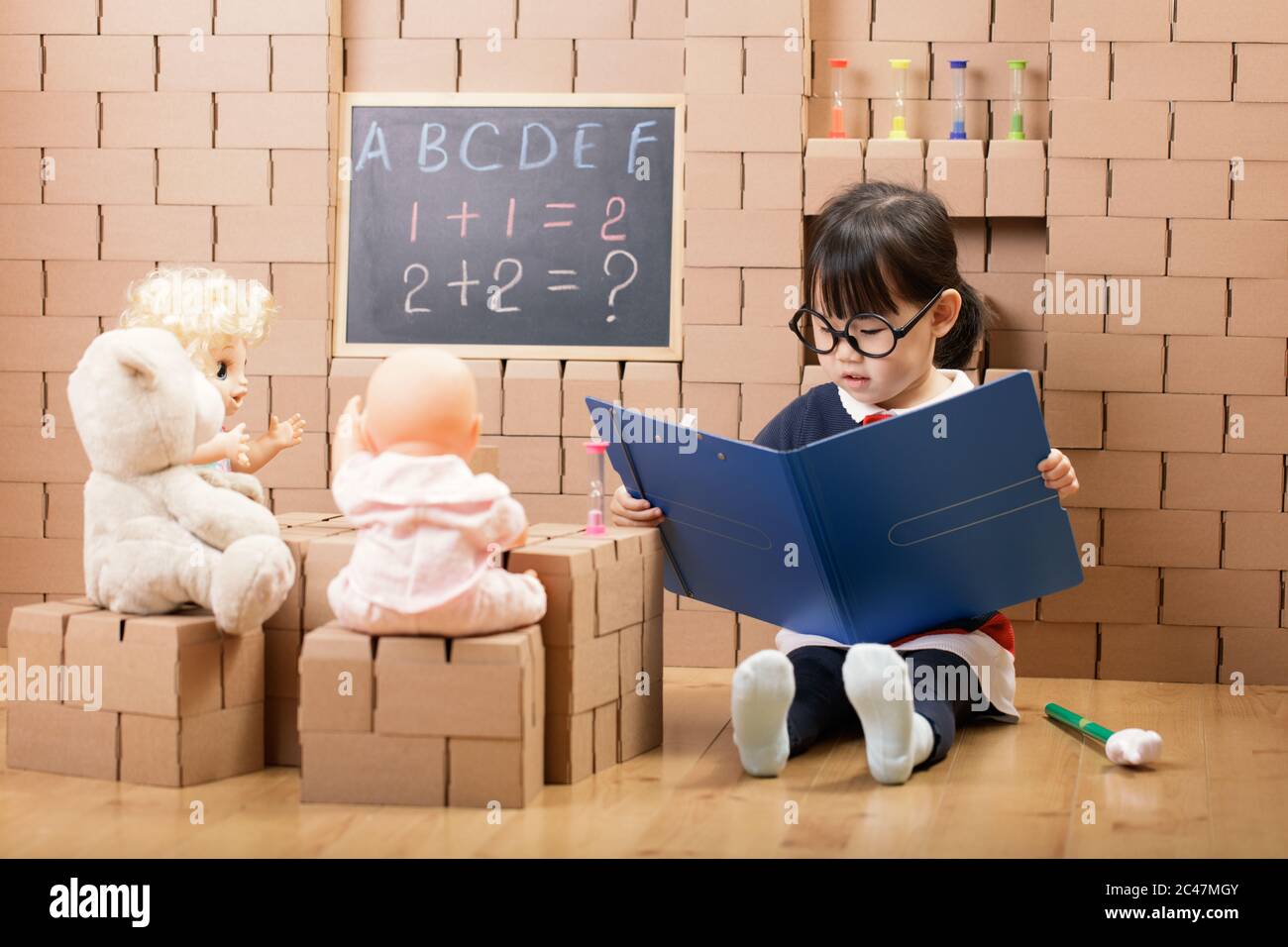 toddler girl pretend play as a teacher at home Stock Photo Alamy