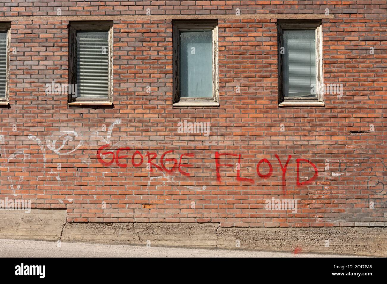 George Floyd spray painted with red on an old brick wall in Munkkisaari district of Helsinki, Finland Stock Photo