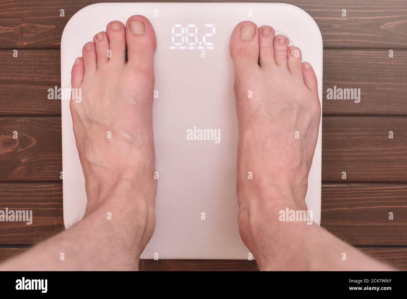 men's feet on an modern electronic scales. sports concept Stock Photo