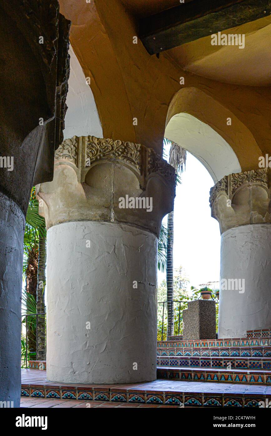 Winding stairs made of decorative Spanish tile, alongside stout columns with scroll work at the historic Santa Barbara County Courthouse, CA Stock Photo