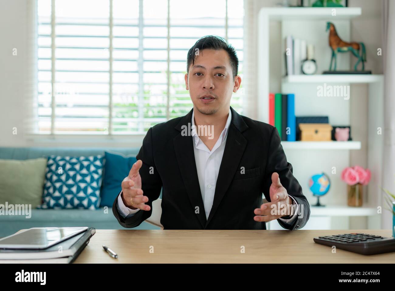 Mixes race Businessman talk with his client by video call communication remote location use modern meeting online in living room at home for social di Stock Photo