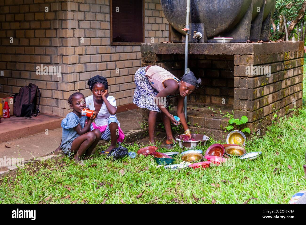 Washing-up the crockery in Sierra Leone Stock Photo