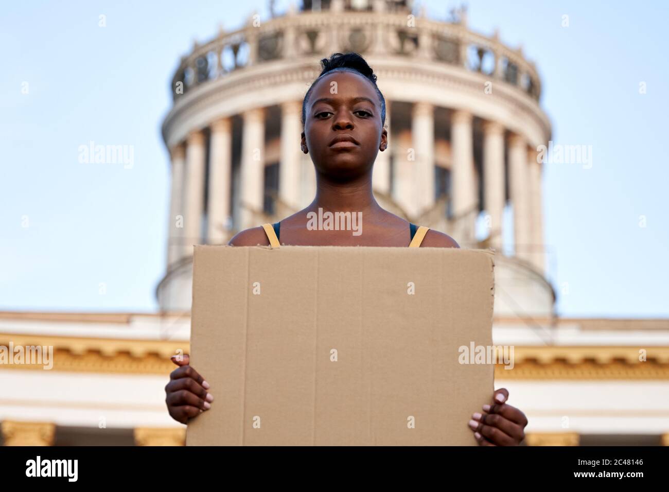 Young african woman activist stand outdoor hold empty sign protesting on street. Stock Photo
