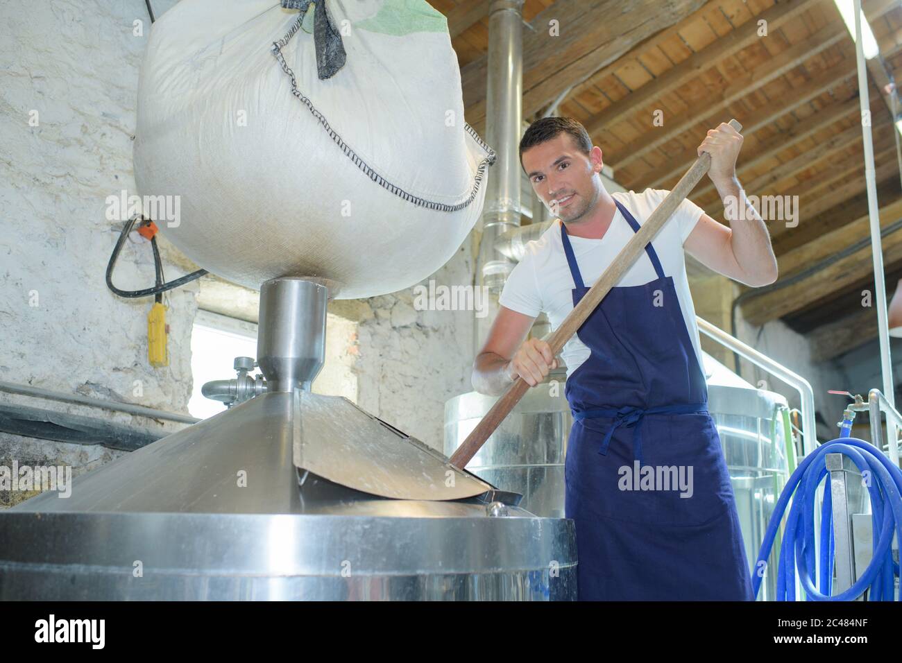 maintenance worker examining brewery machine at brewery factory Stock