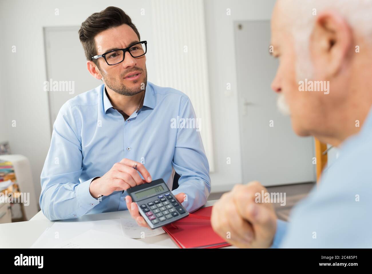 man and customer counting on a calculator Stock Photo - Alamy