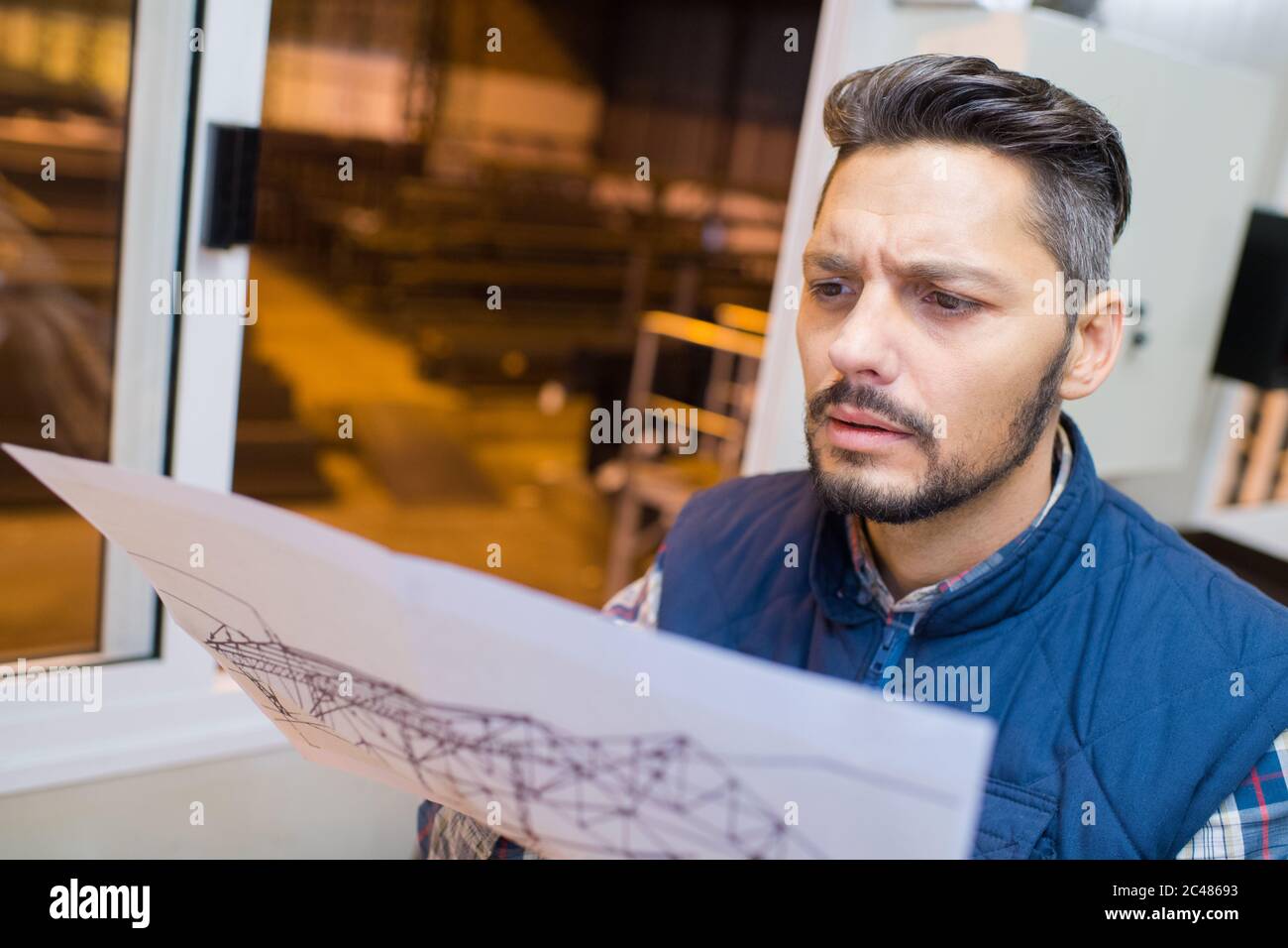 engineer looking paper plans at construction site Stock Photo - Alamy