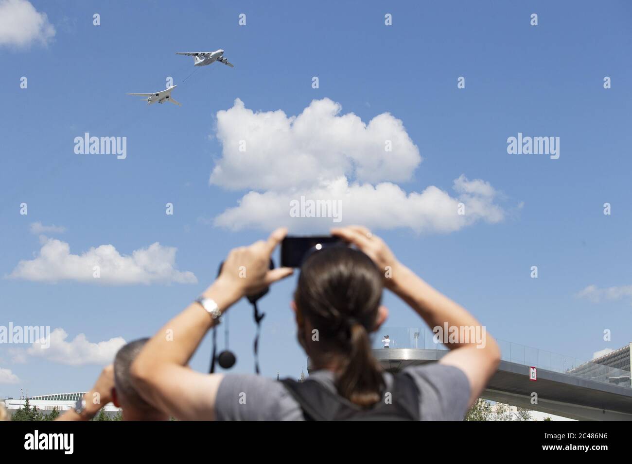 Moscow, Russia. 24th June, 2020. People watch an Il-78 air tanker and a Tu-160 strategic bomber flying over the Red Square during the military parade marking the 75th anniversary of the victory in the Great Patriotic War in Moscow, Russia, on June 24, 2020. Credit: Alexander Zemlianichenko Jr/Xinhua/Alamy Live News Stock Photo