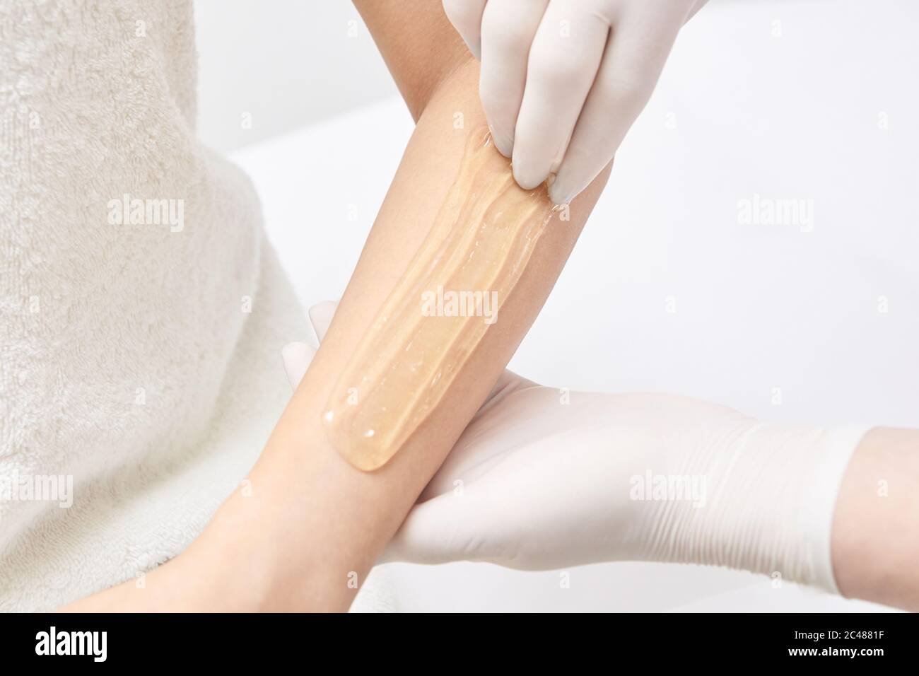 Sugar hair removal from woman body. Wax epilation spa procedure. Procedure beautician female