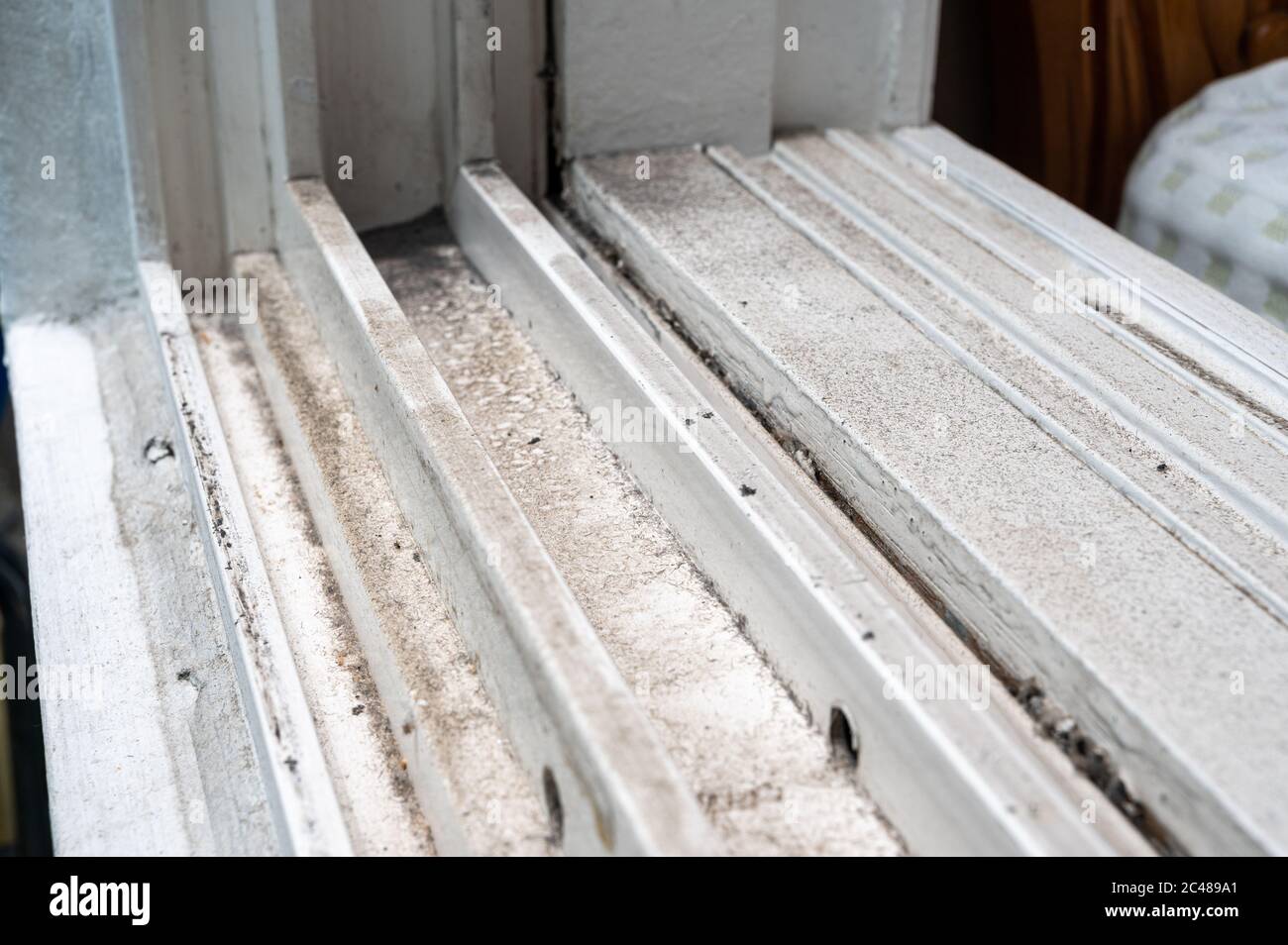 dirty dust piled up in plastic window frames. Stock Photo