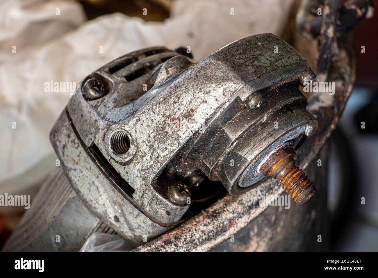 An old angle grinder in bucket. A damaged electrical hand tool ready for repair. Stock Photo