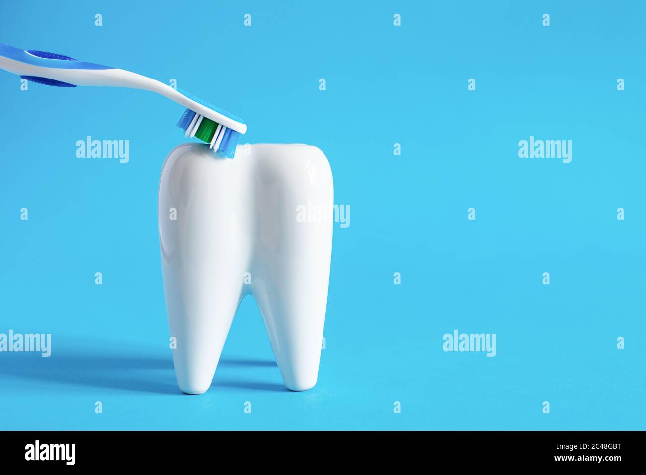 Model of white tooth and toothbrush on blue background. Dental care ...