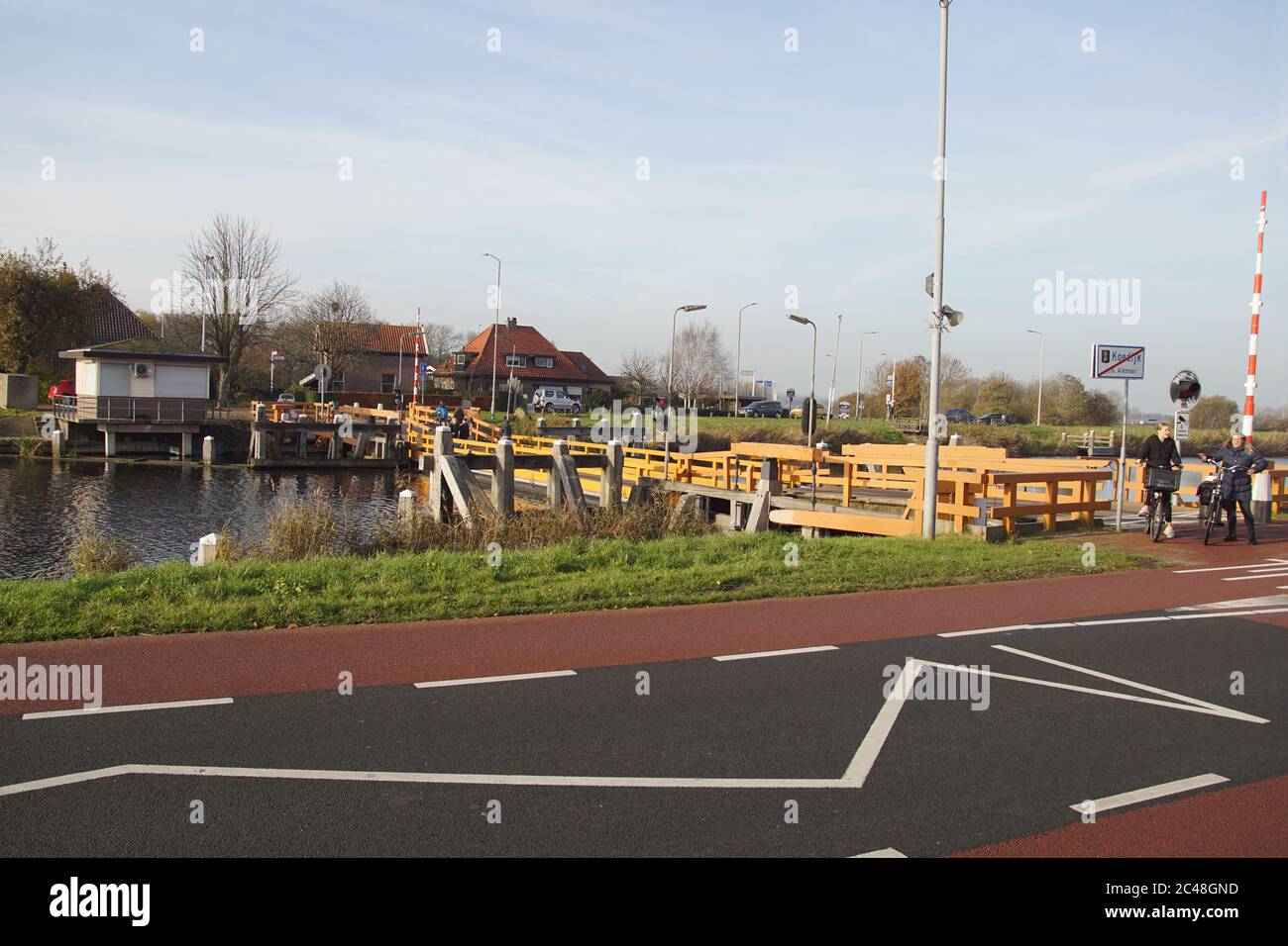 Float bridge In a canal in the Dutch village of Koedijk. Retractable pontoon bridge opening for water traffic by retracting in its long direction. Stock Photo
