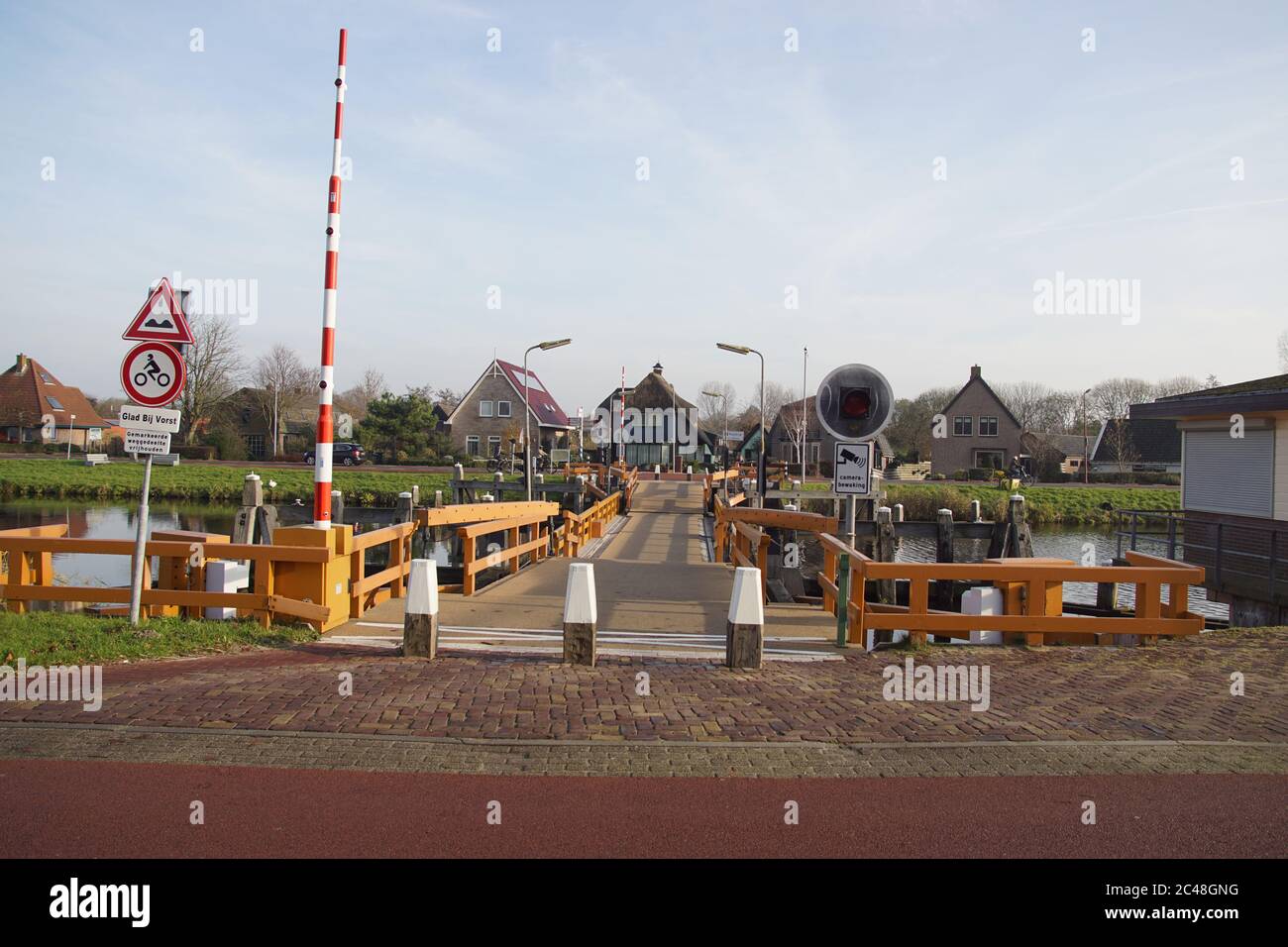 Float bridge In a canal in the Dutch village of Koedijk. Retractable pontoon bridge opening for water traffic by retracting in its long direction. Stock Photo