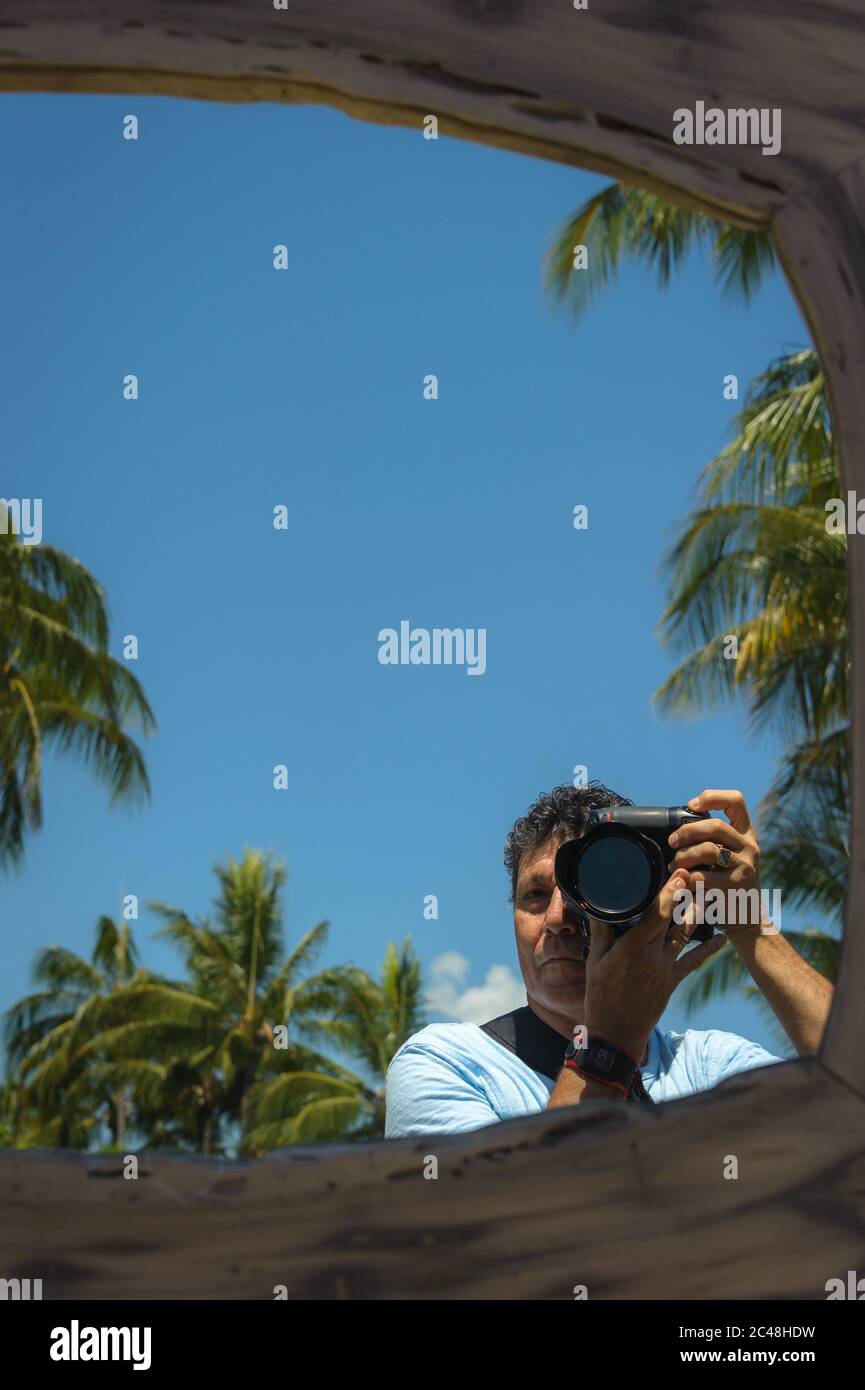 A reflection of a travel and lifestyle photographer taking an environmental self-portrait at the Port Douglas Markets in Far North Queensland. Stock Photo