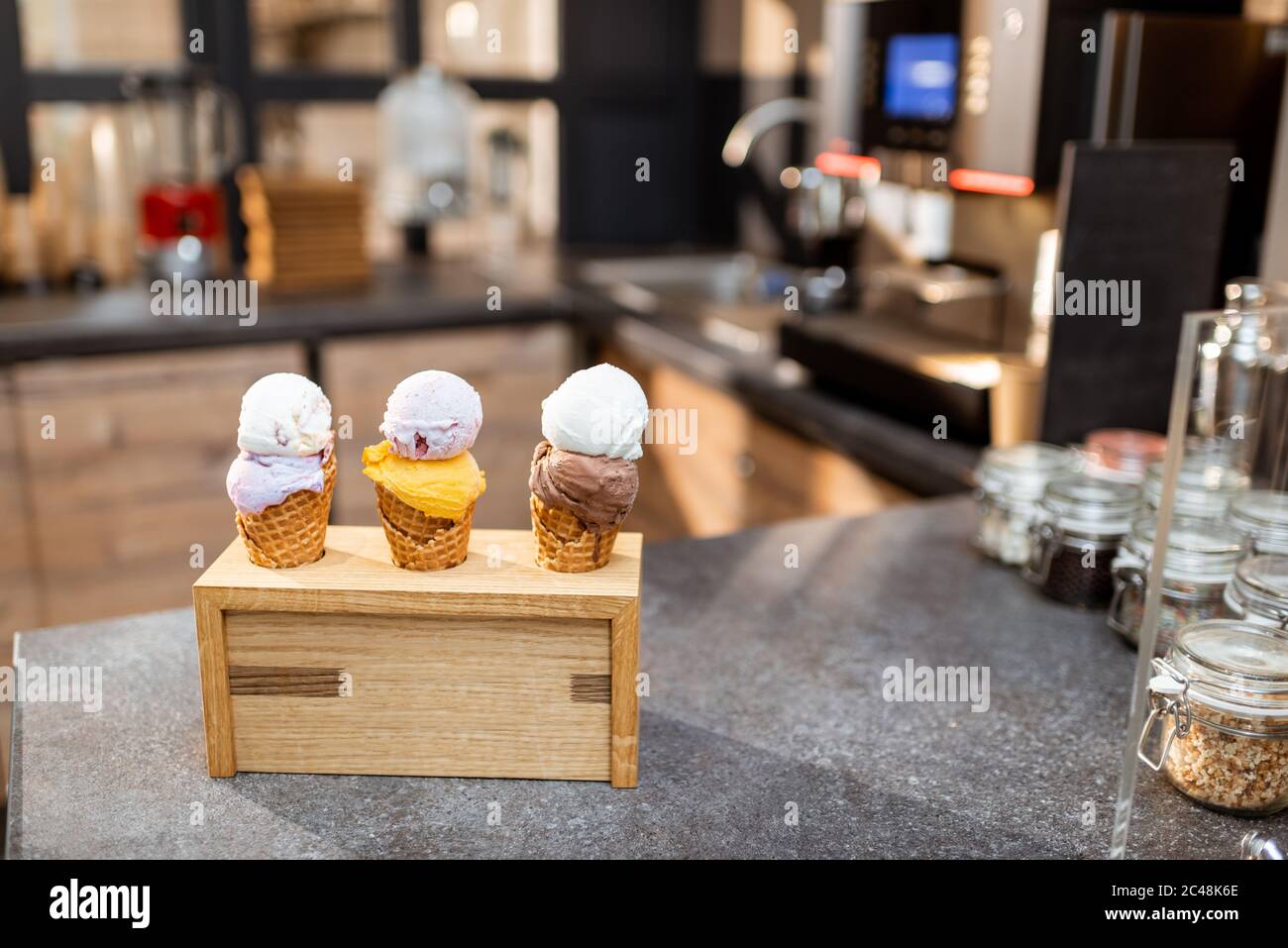 Ice cream in waffle cone with different flavors on the store counter ...