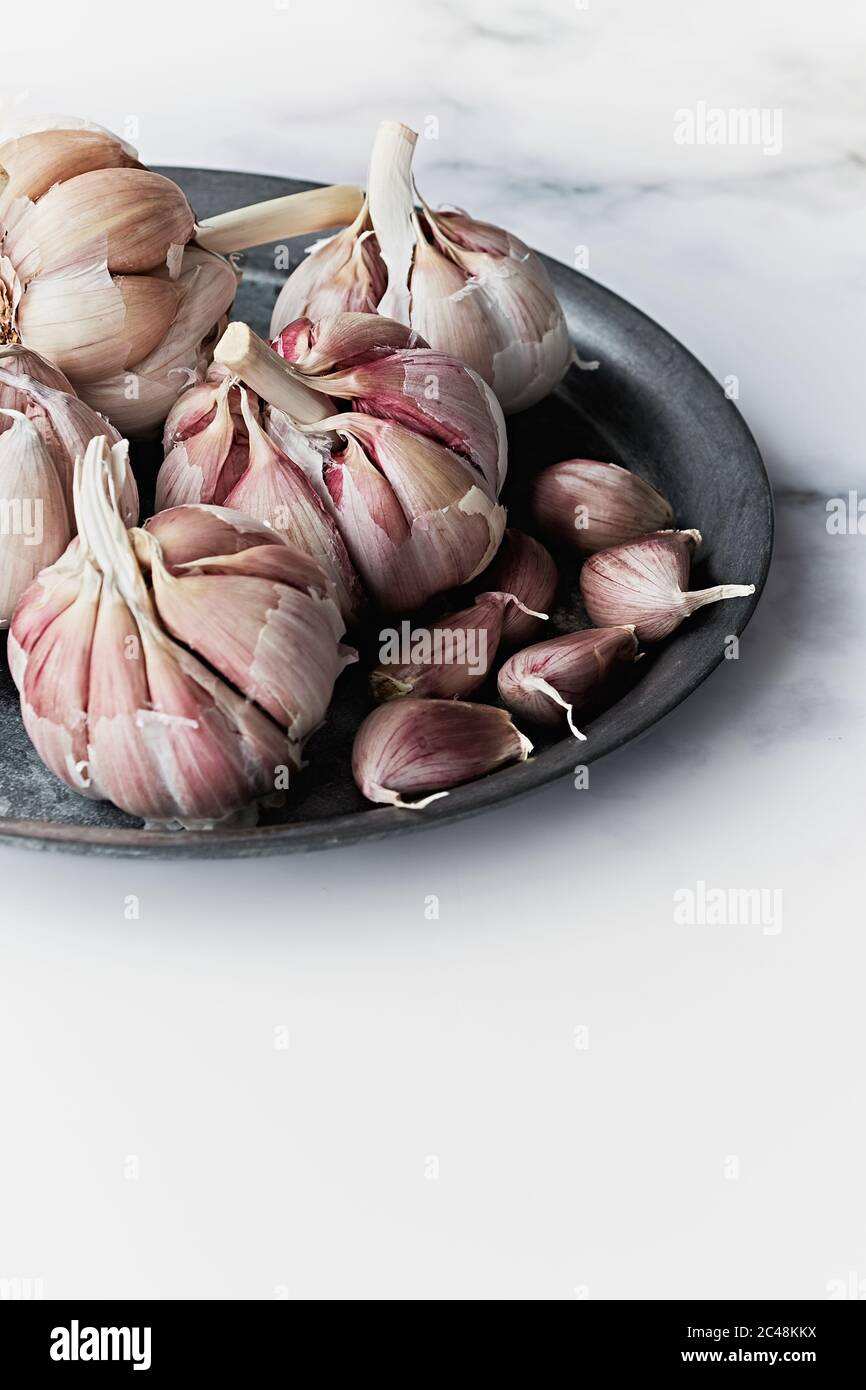Raw garlic on the kitchen table Stock Photo - Alamy