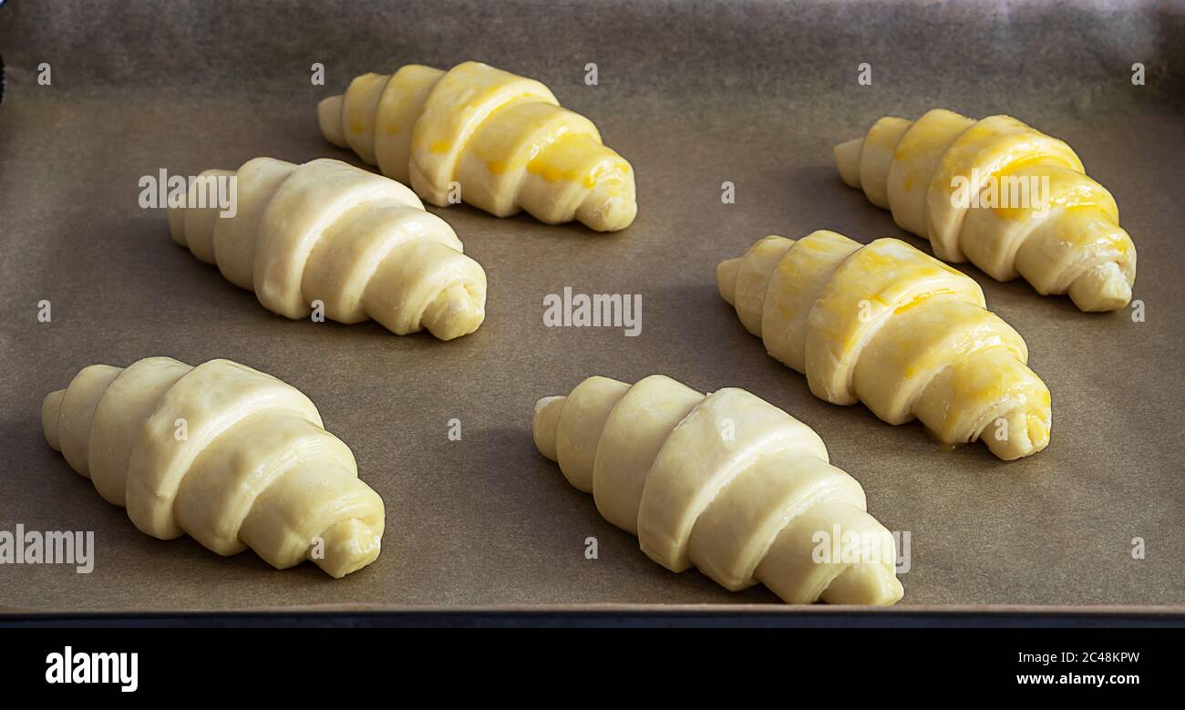 Fresh raw butter croissants laying on parchment. Stock Photo