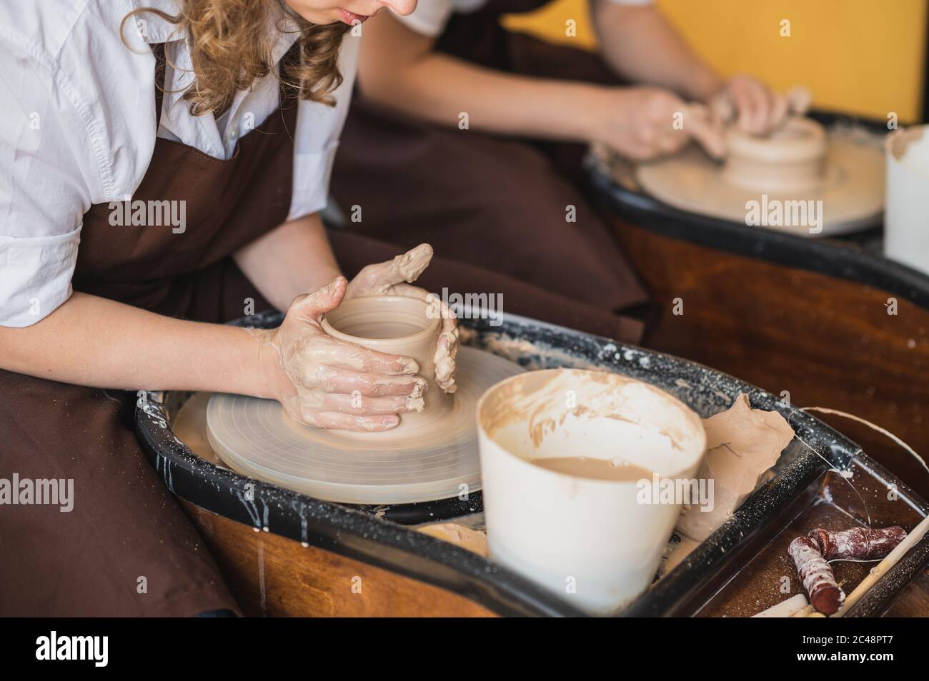 The manufacture of ceramics. Two woman prepare clay for work on pottery