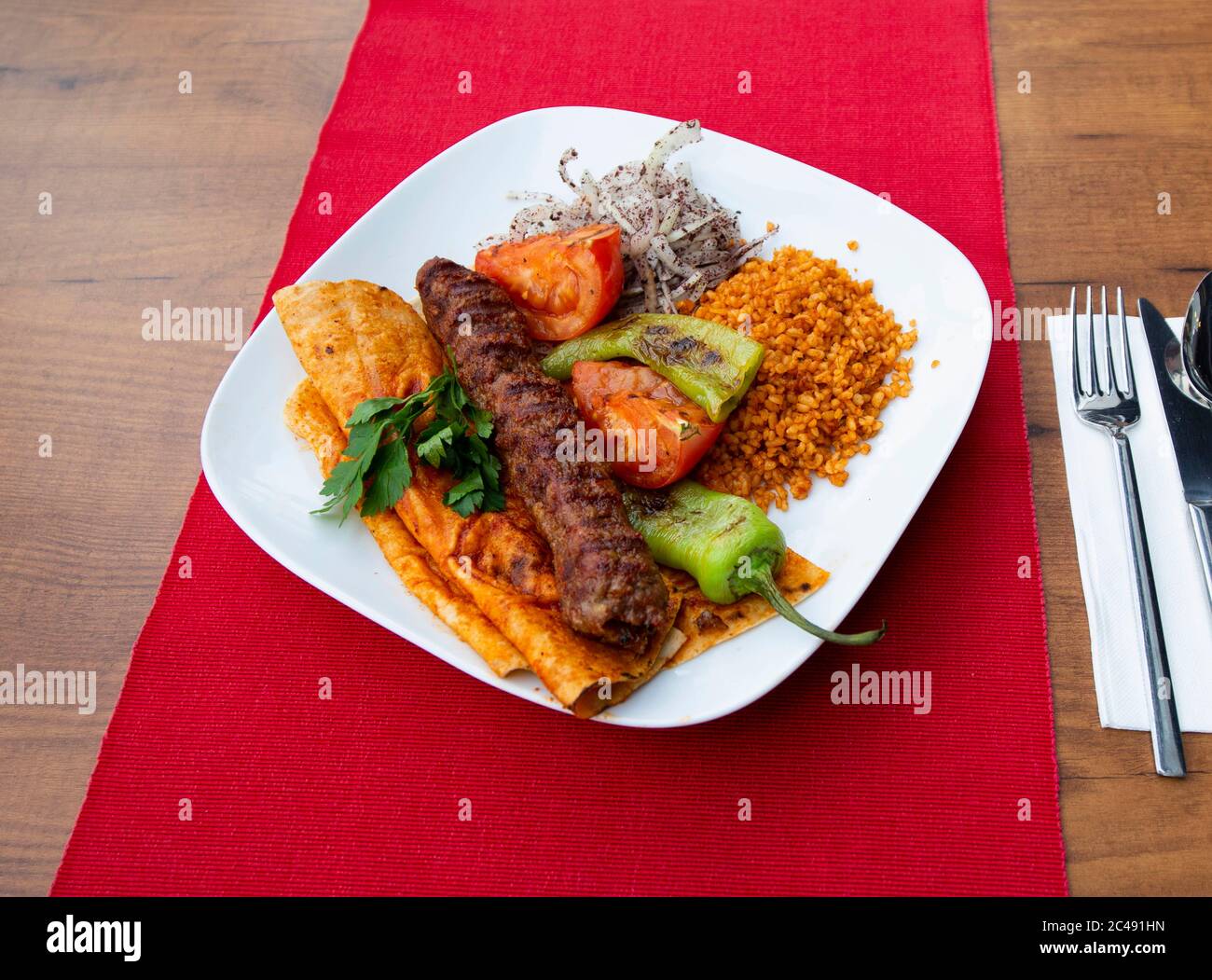 Turkish Adana Kebap With bulgur pilaf And Vegetables Served On A Plate