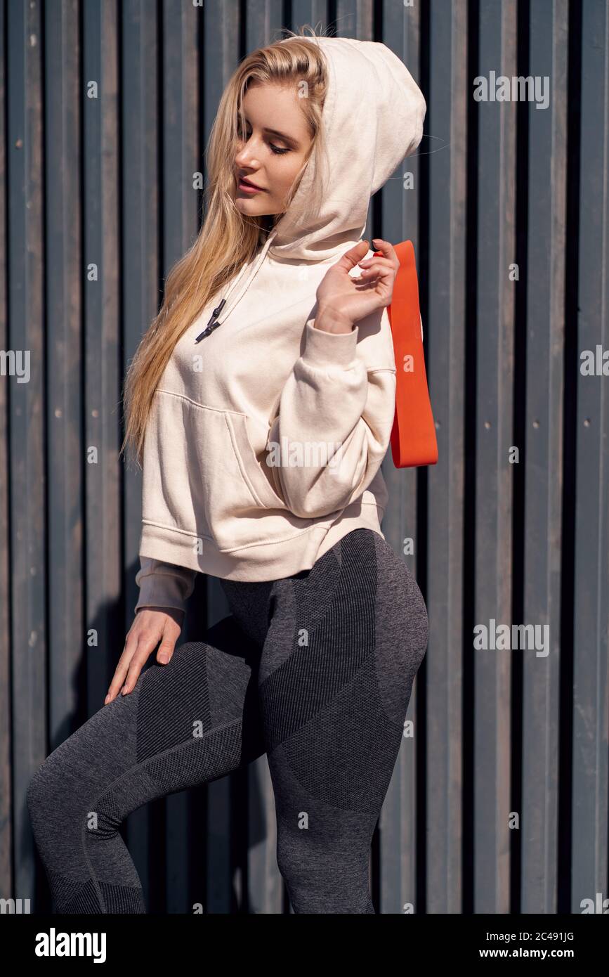 Beautiful young blonde woman in beige hoodie doing sport outdoor.Attractive  female spending active time in the park Stock Photo - Alamy
