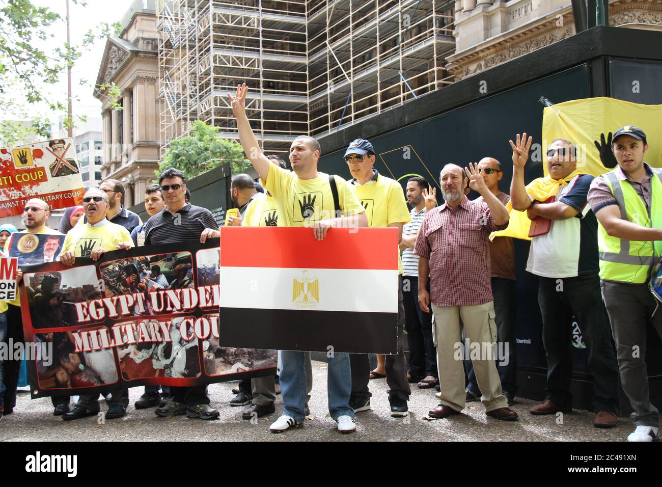 Protesters make the Muslim Brotherhood symbol with their hands at a rally outside Sydney Town Hall in support of ousted Egyptian president Mohamed Mor Stock Photo
