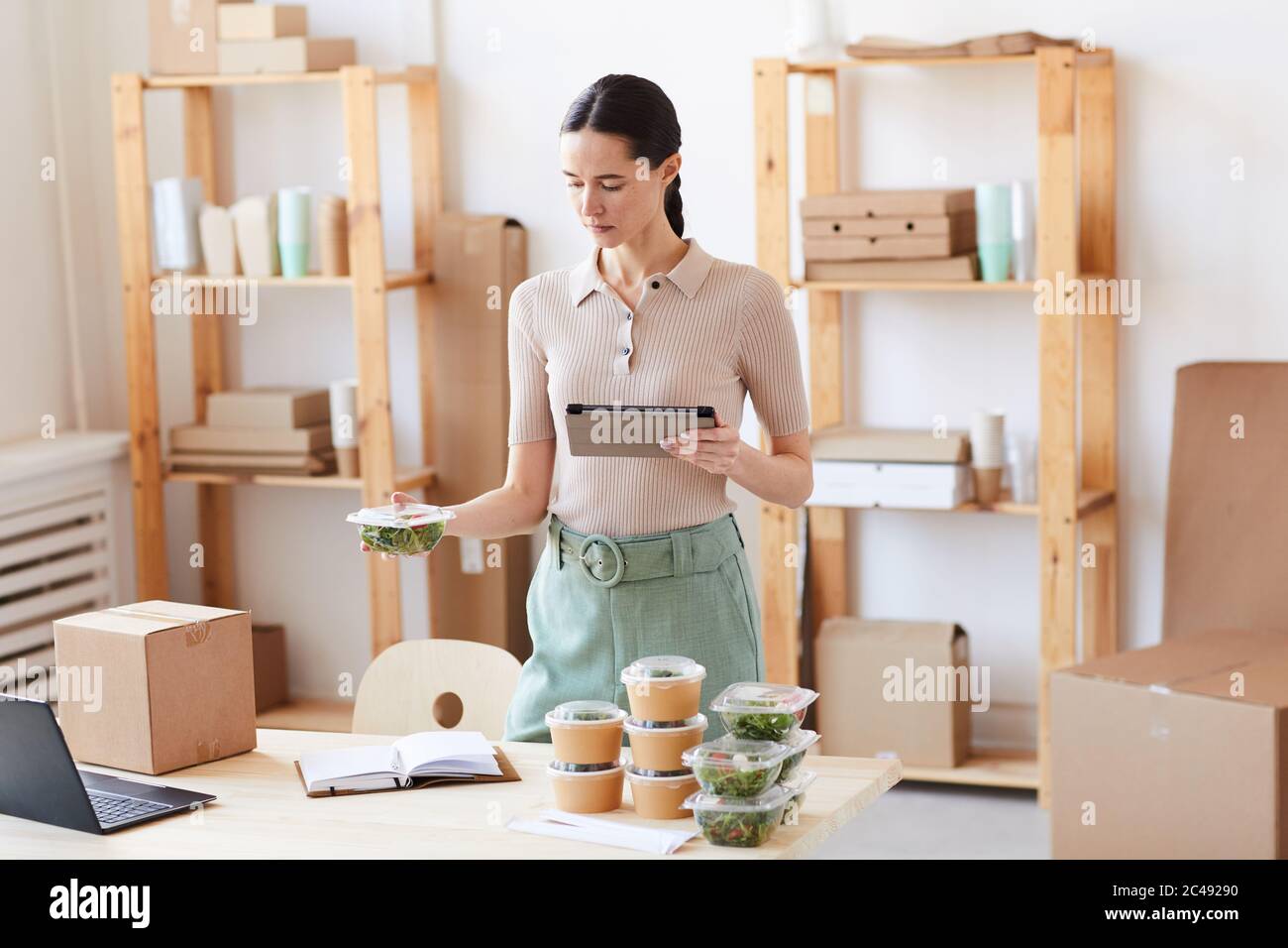 Young woman using digital tablet she working at office and organizing the food delivery Stock Photo