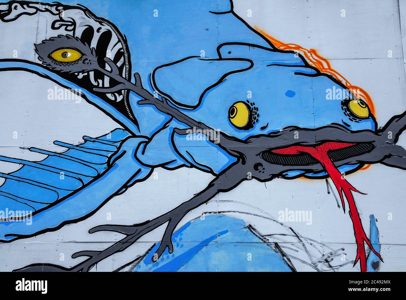 New to science … this blue catfish with four yellow eyes, a barbed red tongue and a zip-up body revealing its skeleton was among the artworks painted – legally – by street artists on a hoarding surrounding a former wine warehouse on the quayside of the northeast Italian port of Trieste, Friuli-Venezia Giulia, Italy, to promote Trieste Fest 2007, an international festival dedicated to the communication of science. Stock Photo