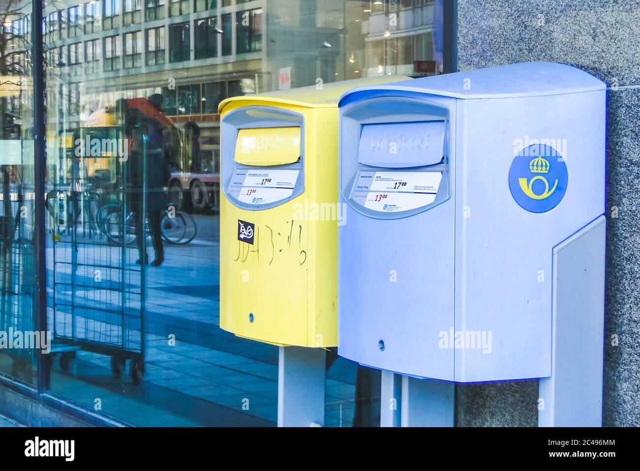 STOCKHOLM, SWEDEN - MAR 21, 2013 - Blue and yellow mailboxes in Stockholm, Sweden near shop showcase. Stock Photo