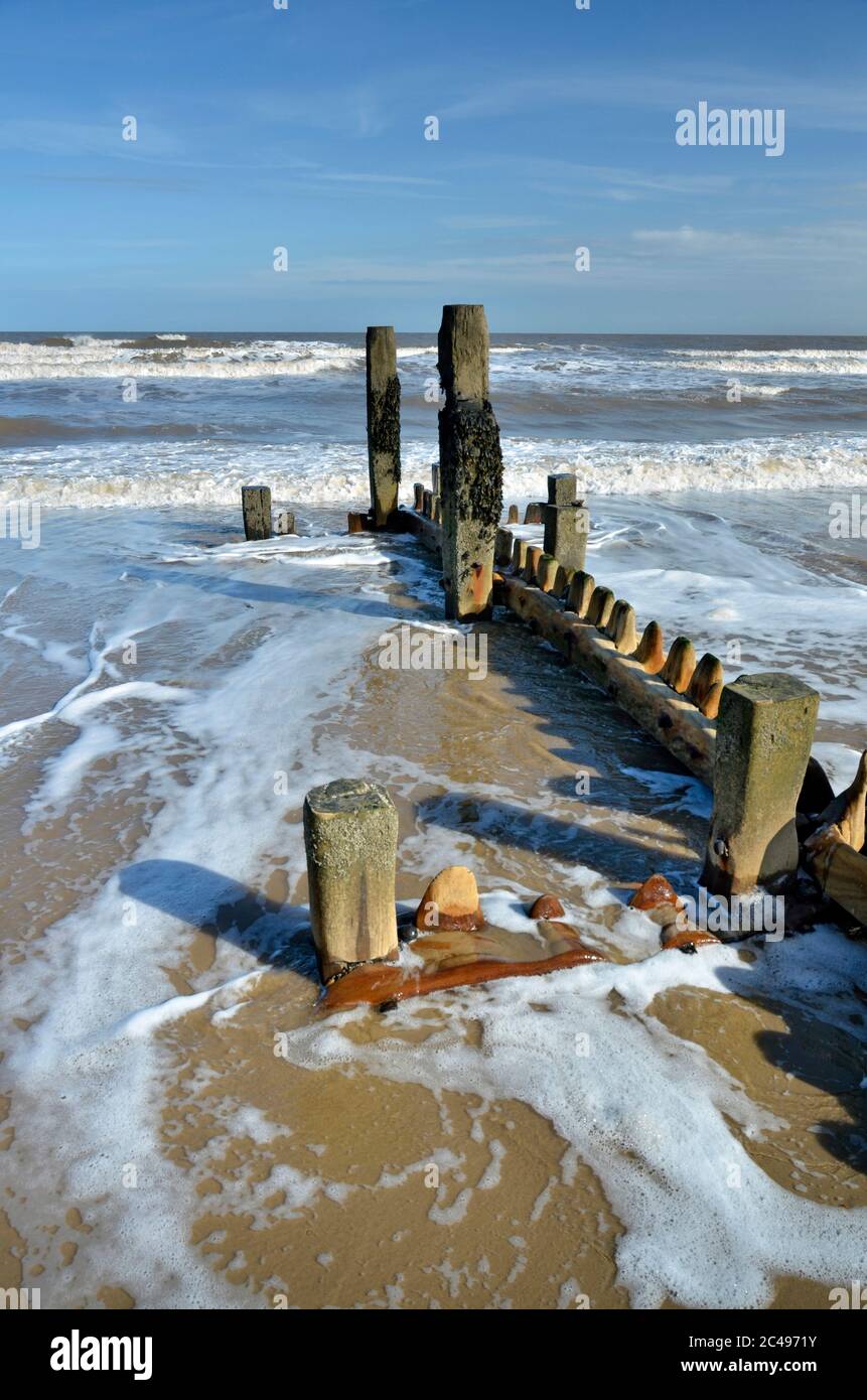 north sea swirling around wooden groynes mundesley north norfolk england Stock Photo