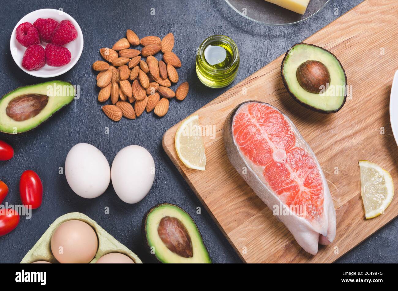 Keto diet, low carb healthy food. avocado, fish, oil, nuts on black