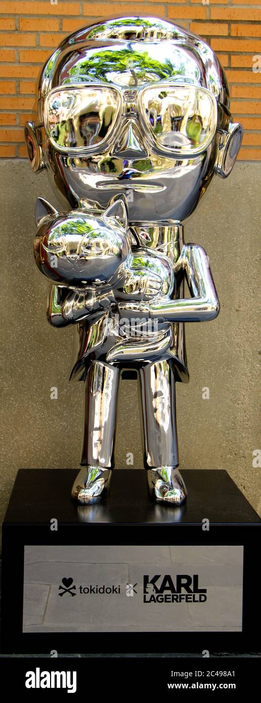 Small silver chromed statue in tribute to German clothes designer Karl  Lagerfeld holding a cat Madrid Spain Stock Photo - Alamy