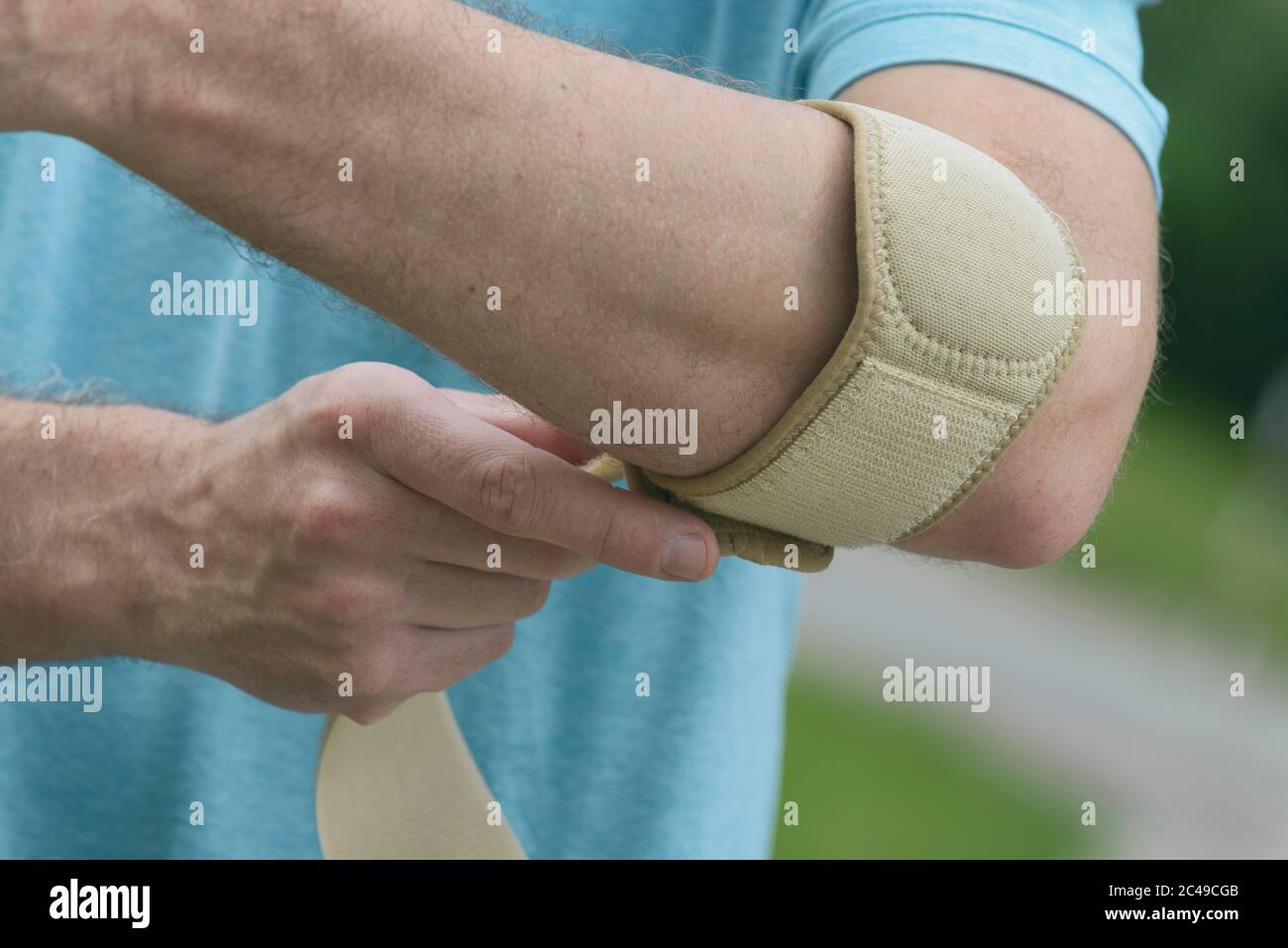 Man wearing elbow brace to reduce pain Stock Photo Alamy