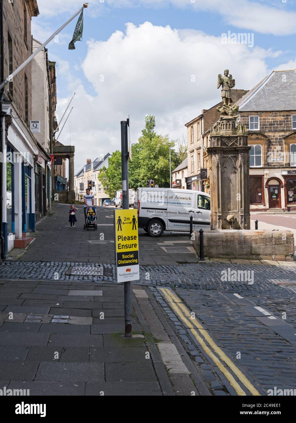 Quiet streets of a usually vibrant market town, Alnwick, Northumberland, UK and a 2m social distancing sign during the 2020 coronavirus pandemic. Stock Photo