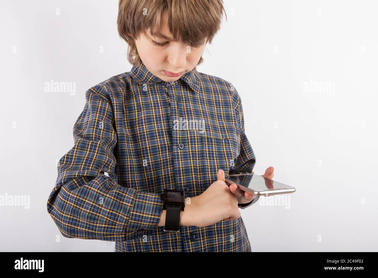 Boy pairing his smart watch with a smartphone Stock Photo