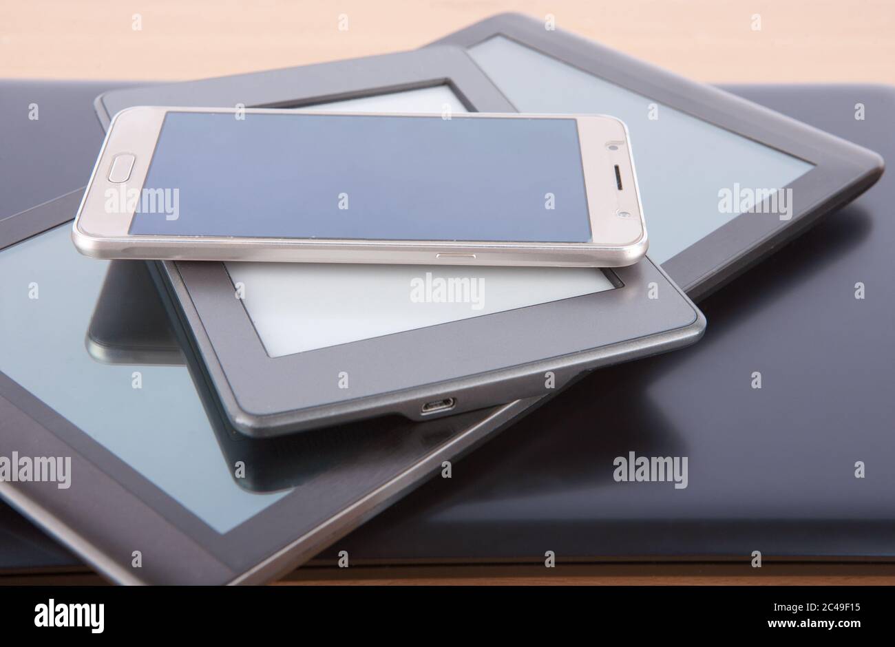 Stack of gadgets on a desk - notebook, tablet, ebook reader and a ...