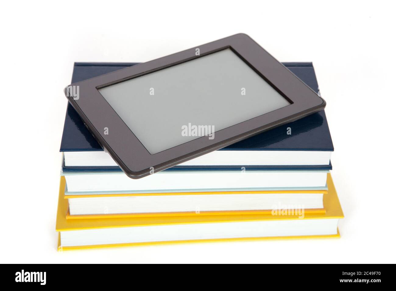 Ebook reader with empty screen on top of pile of paper books. Isolated