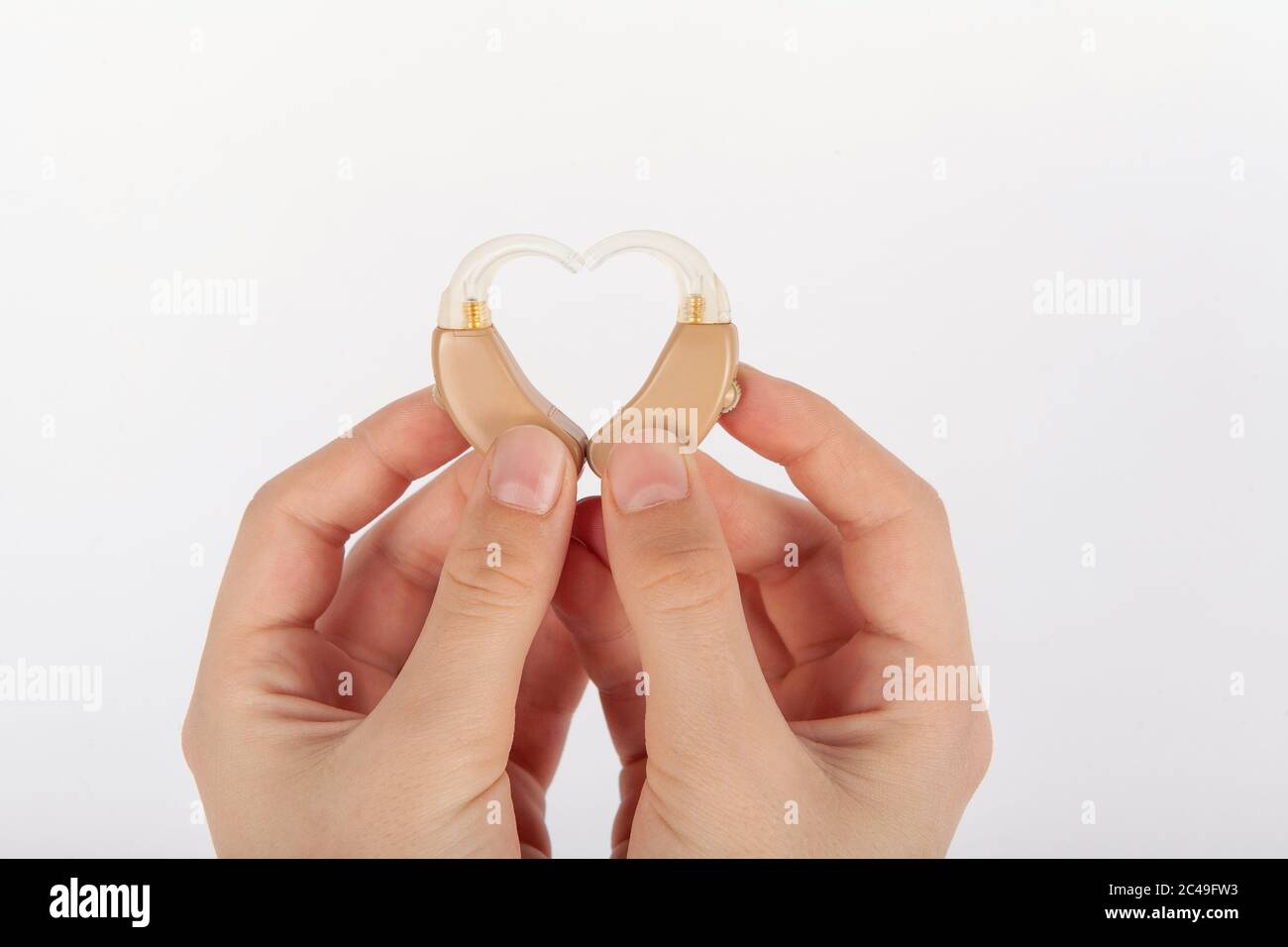 Heart shape formed by a hands with hearing aids Stock Photo