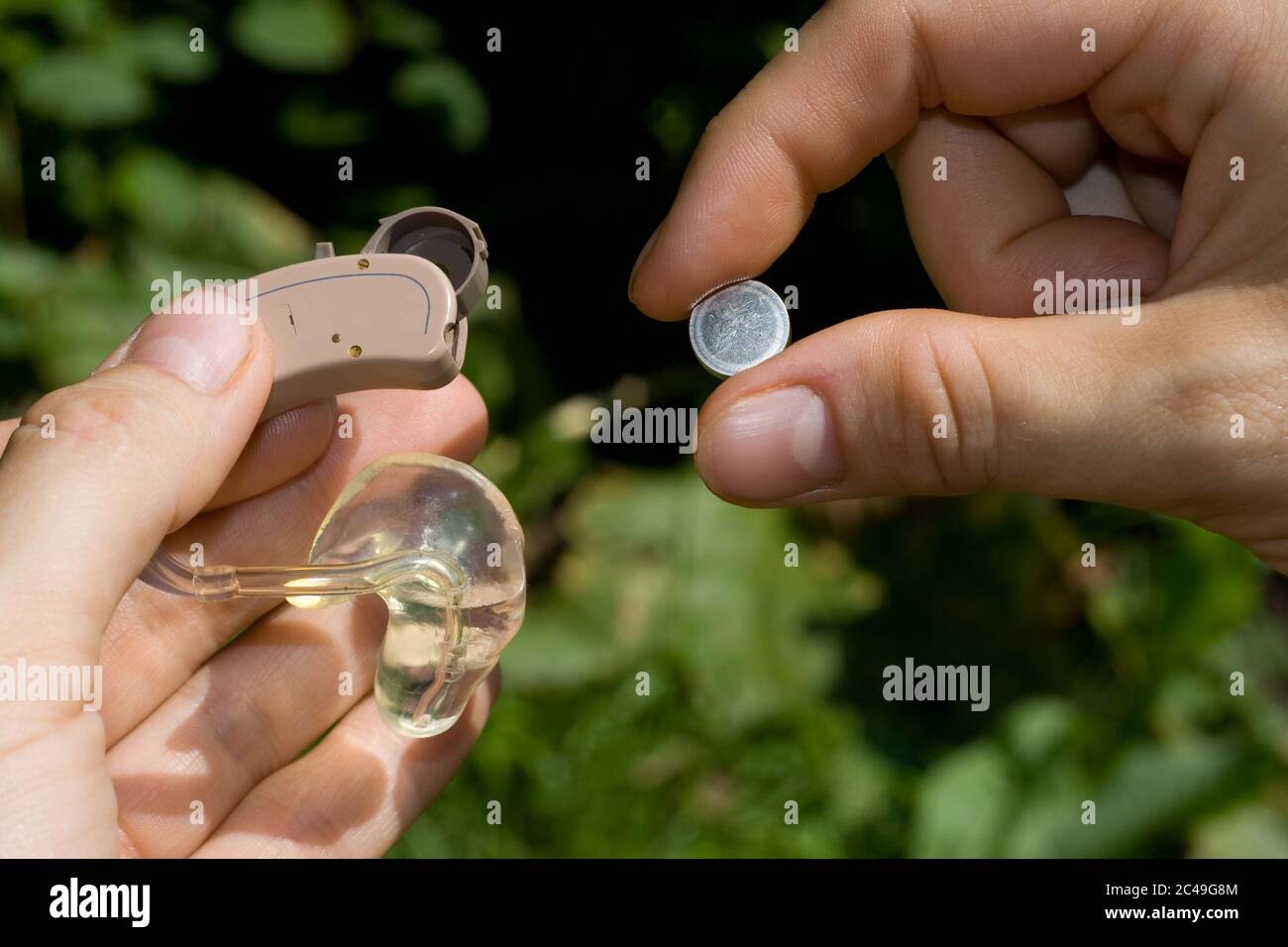 Changing a digital hearing aid battery Stock Photo Alamy