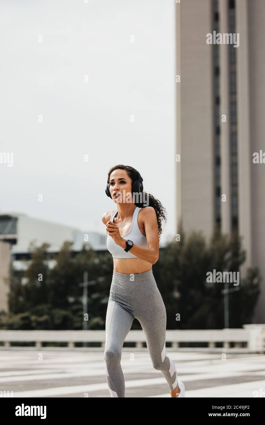 Woman runner in jogging outfit running on a street. fitness woman running outdoors in morning. Stock Photo