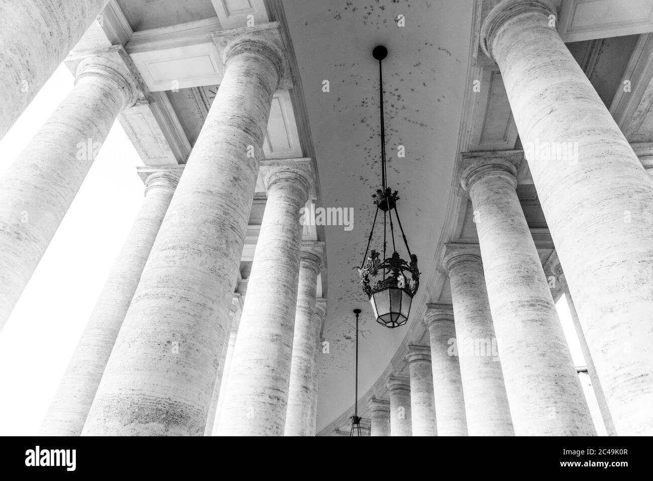 Row of white travertine columns. Monumental Doric colonnade of St Peters Square in Vatican City. Black and white image. Stock Photo
