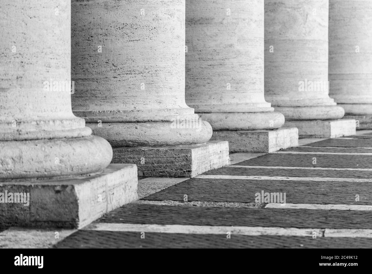 Row of white travertine columns. Colonnade of St Peters Square in Vatican City. Black and white image. Stock Photo