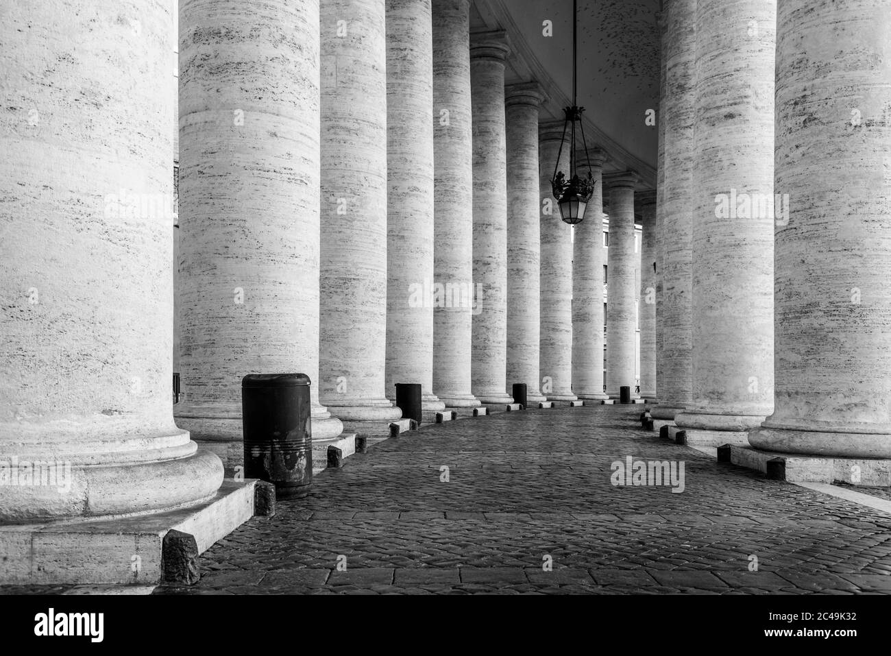 Row of white travertine columns. Monumental Doric colonnade of St Peters Square in Vatican City. Black and white image. Stock Photo