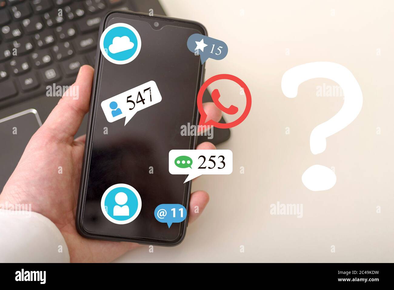 The hand uses a smartphone and a hologram of various icons including a question mark. Concepts of social networks. Stock Photo