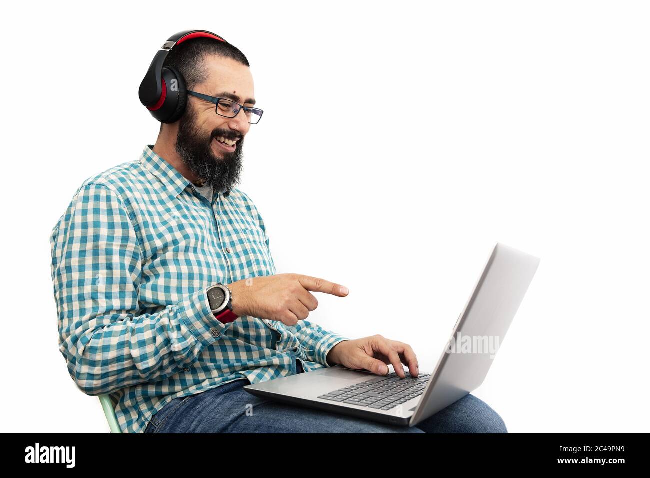 man isolated on white background laughing as he points at his computer screen, communication and technology concept Stock Photo