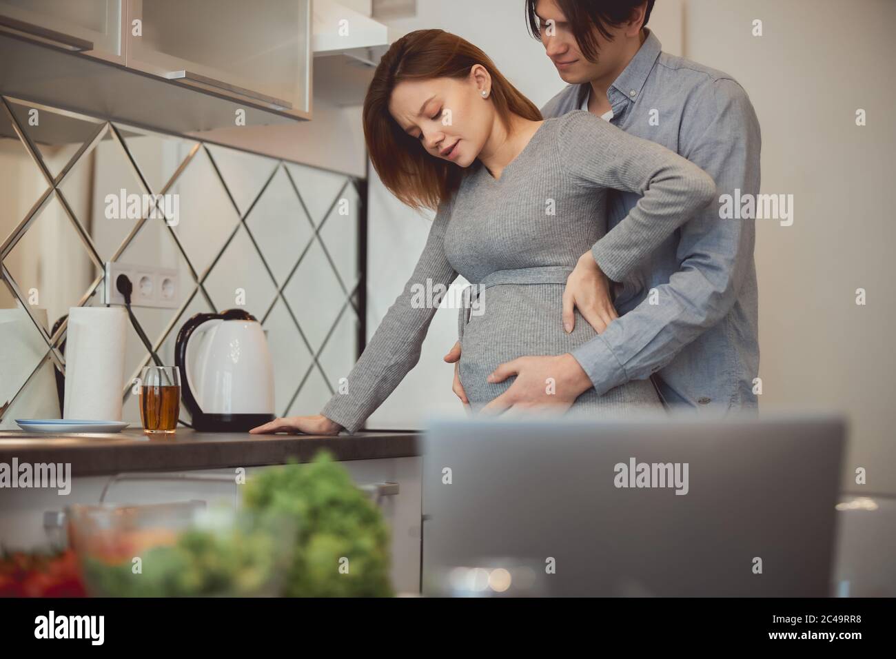 Relieving pain during the contractions at home with gentle touch Stock Photo