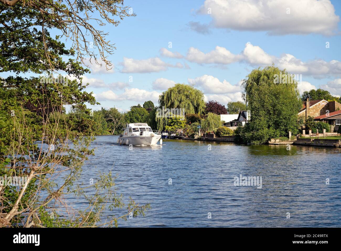 Riverside houses and private boats on a summers day by the River Thames