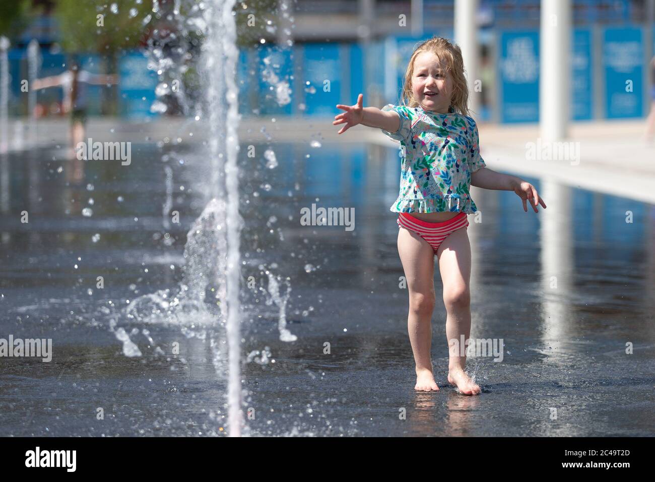 Three year old girl having fun in water fountains, Centenary Square, Birmingham UK Stock Photo