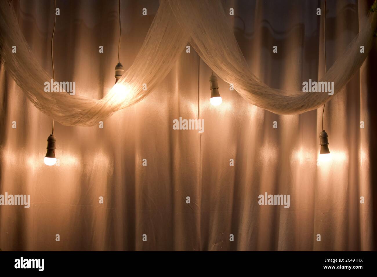light bulb with yellow light and white cloth as a wedding room decoration.  can be used as background and wallpaper Stock Photo - Alamy