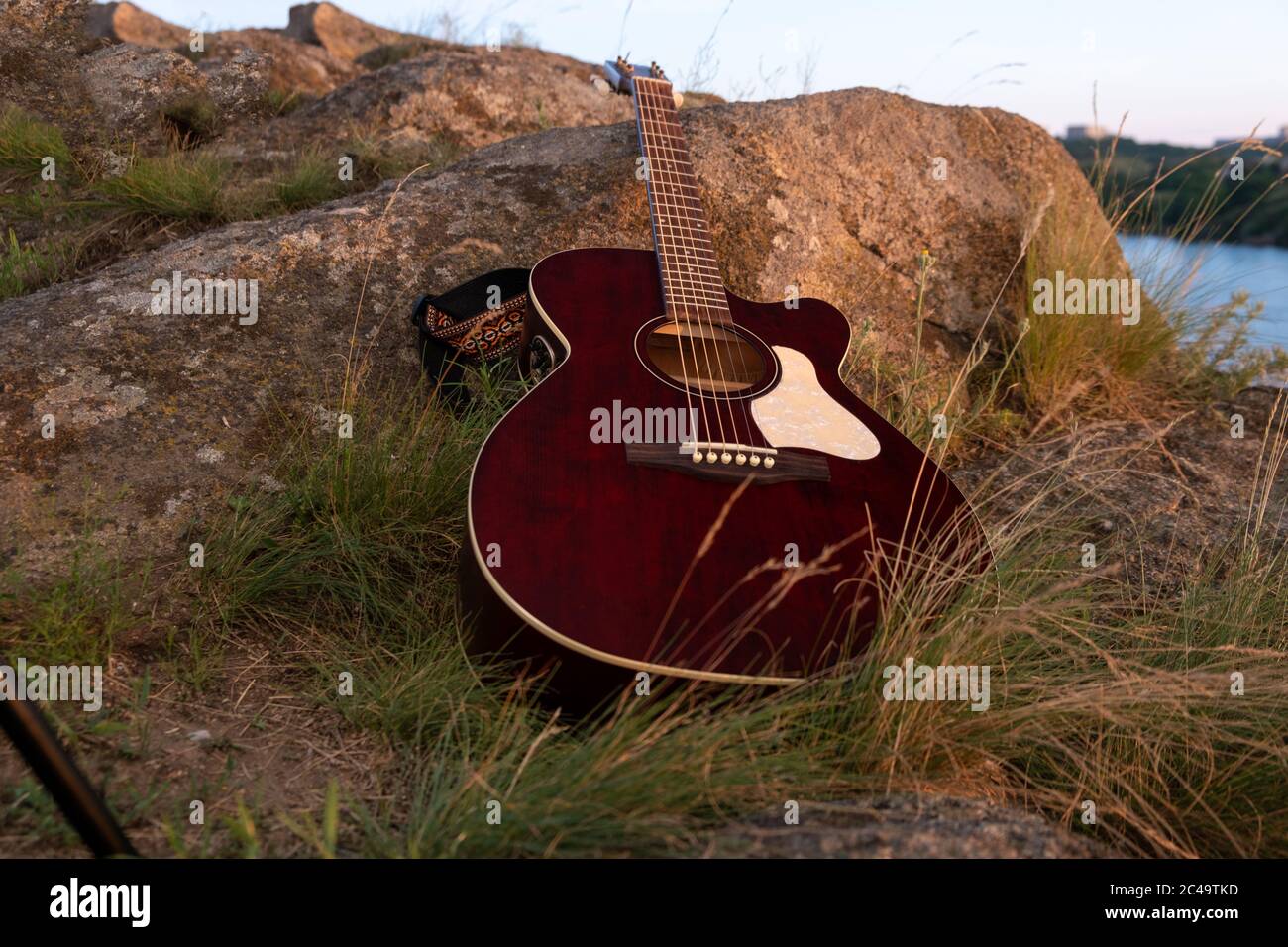 acoustic guitar on the rock. guitar at the sunset, music background concept Stock Photo